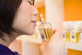 an image of a girl smelling a perfume.